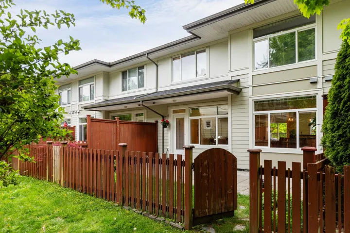 Back of property featuring a fenced front yard and a gate