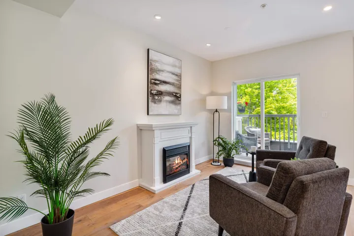 Living area featuring baseboards, recessed lighting, a glass covered fireplace, and light wood-type flooring