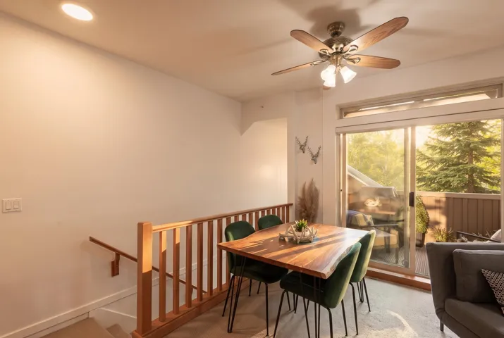 Dining area with wood-finish railing and recessed lighting