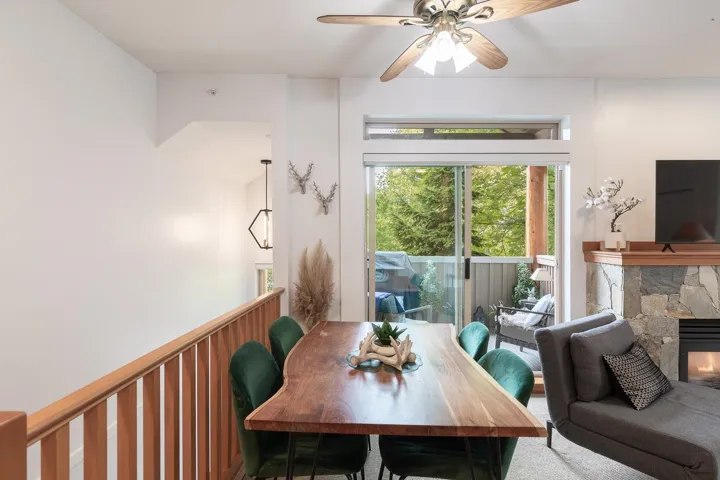 Open-concept living space featuring a stone-faced fireplace with a wood mantel