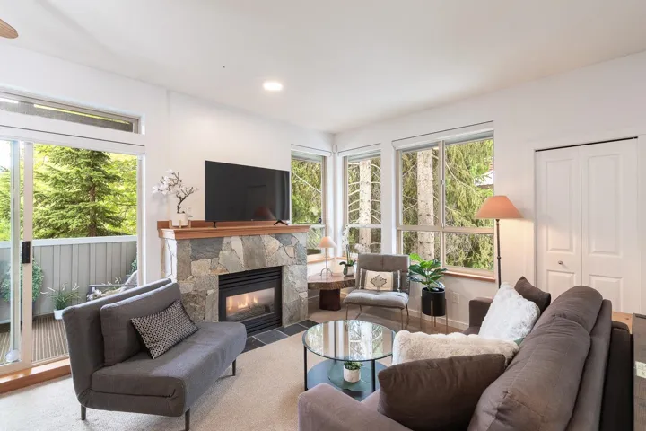 Living area featuring a stone-clad fireplace with a wood mantel, a gas insert, and a tiled hearth