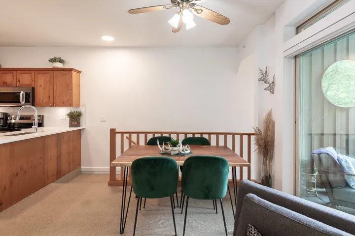 Open-concept kitchen and dining area featuring warm-toned wood cabinetry, stainless steel appliances, and a light-colored countertop