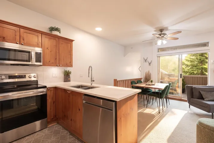 Kitchen featuring natural wood-finish cabinetry, stainless steel appliances, and light-toned countertops