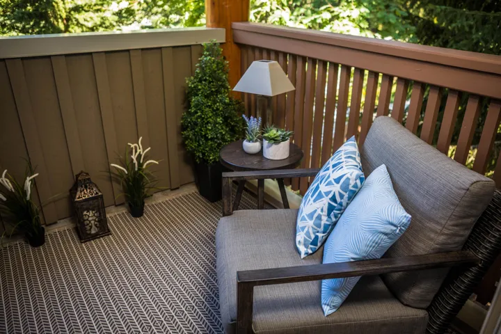 Private balcony featuring a wood railing and a vertical plank exterior wall