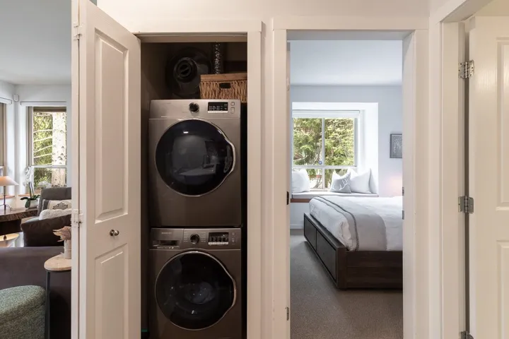 Dedicated laundry closet featuring a stacked washer and dryer