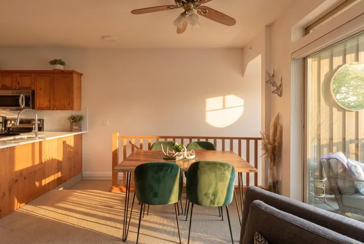Open-concept dining area featuring a wood-finish dining table and a ceiling fan