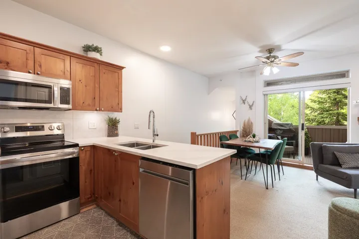 Kitchen area featuring wood cabinetry, stainless steel appliances, and light-toned countertops