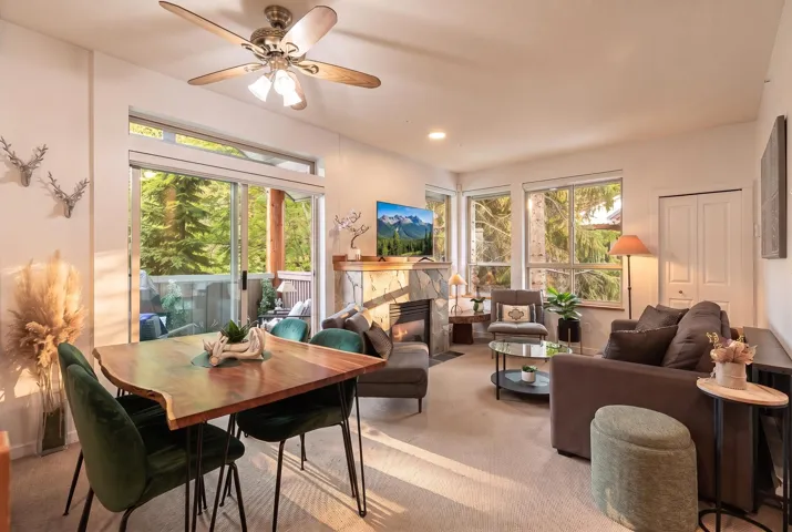 Living area with a stone-clad fireplace and mantle, recessed lighting, and a ceiling fan