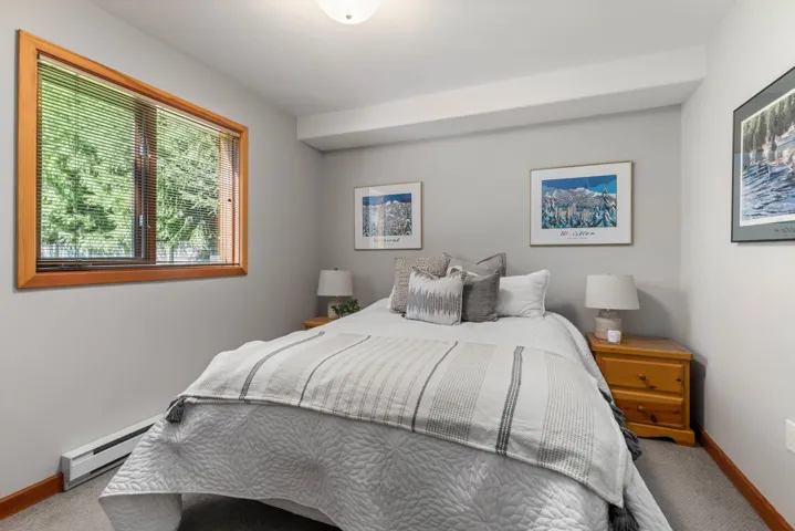 Carpeted bedroom with baseboards and baseboard heating