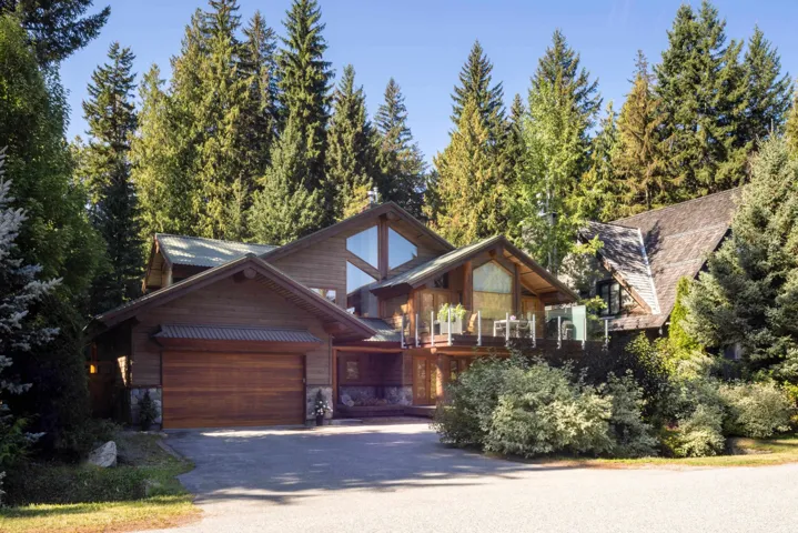 View of front of home with asphalt driveway, stone siding, and an attached garage