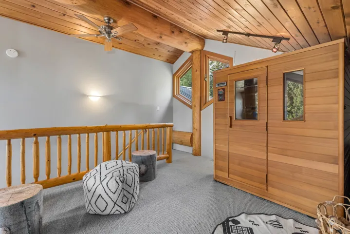 Hallway with a sauna, carpet floors, wood ceiling, an upstairs landing, and wood walls