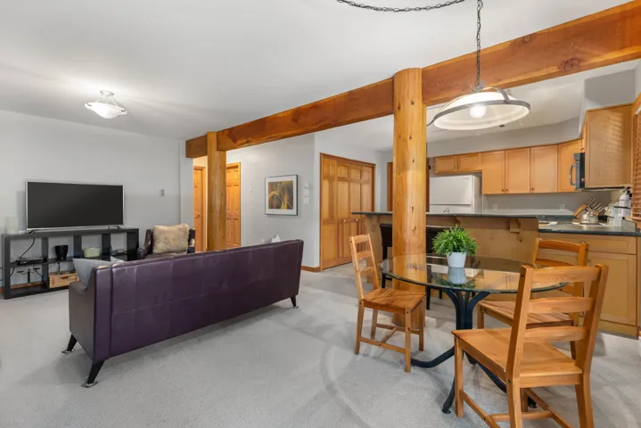 Living area featuring beamed ceiling and light colored carpet