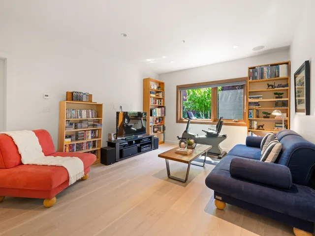 Living area with light wood finished floors and recessed lighting