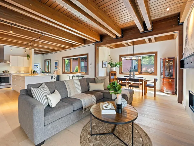 Living area with healthy amount of natural light, light wood-type flooring, a wooden ceiling with exposed beams, and rail lighting