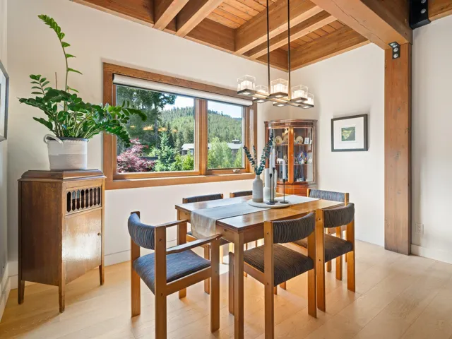Dining space with a wood ceiling with exposed beams, a chandelier, and light wood-type flooring