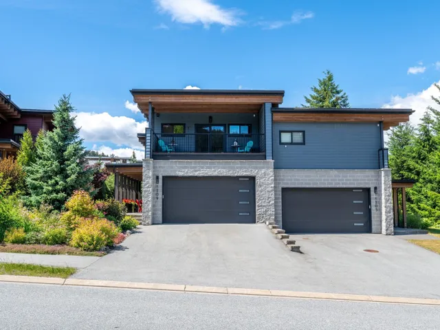 View of front of home with a balcony, driveway, and an attached garage