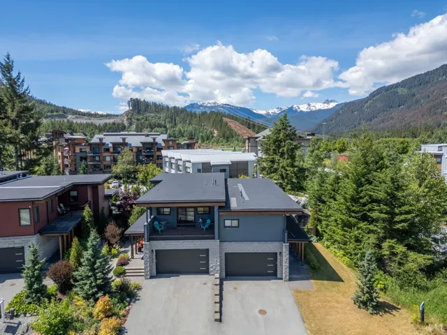 View of front of house featuring an attached garage, driveway, a mountain view, stairs, and a balcony