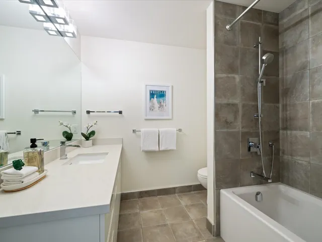 Bathroom with vanity, tub / shower combination, and tile patterned floors