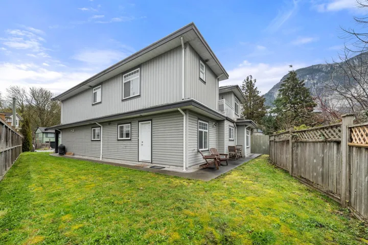 Rear view of property featuring a patio, a yard, and a fenced backyard