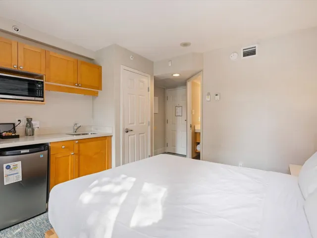 Kitchen featuring visible vents, light countertops, a sink, and fridge