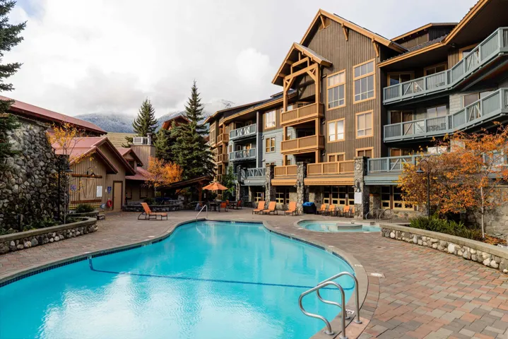 Outdoor swimming pool and hot tub area surrounded by paver patio