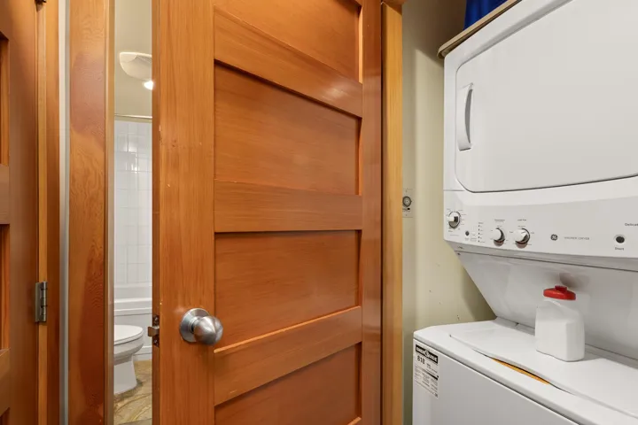 Dedicated laundry area featuring a stacked washer and dryer unit