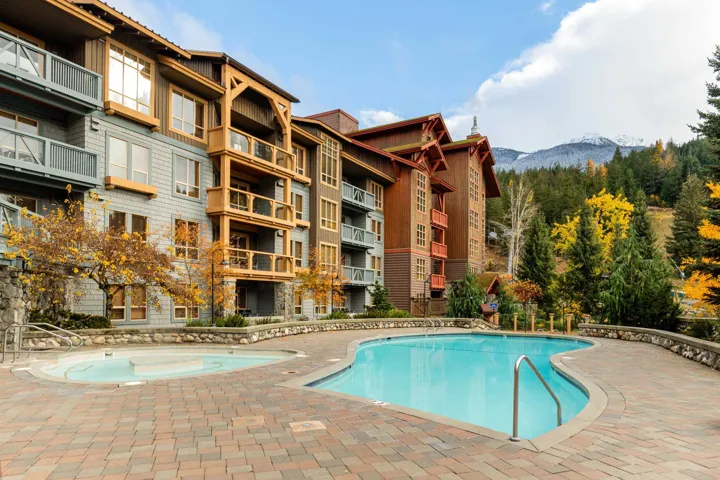 Outdoor swimming pool and spa with paver deck and stone retaining walls