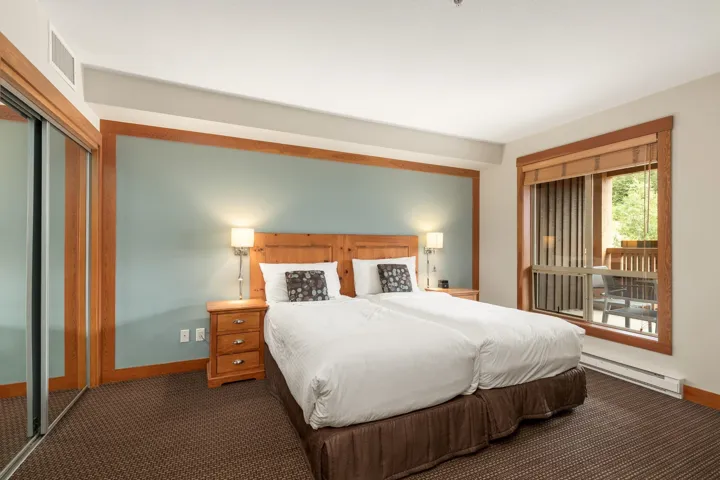 Room featuring a textured accent wall, wood-finish trim, and patterned carpeting