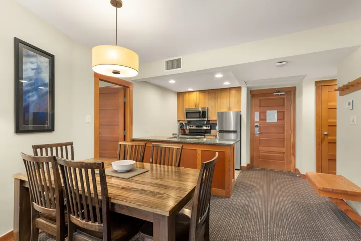 Dining area featuring a wooden dining table with seating for six, illuminated by a drum pendant light
