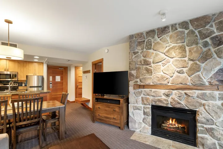 Stone-clad fireplace with wood mantel and hearth