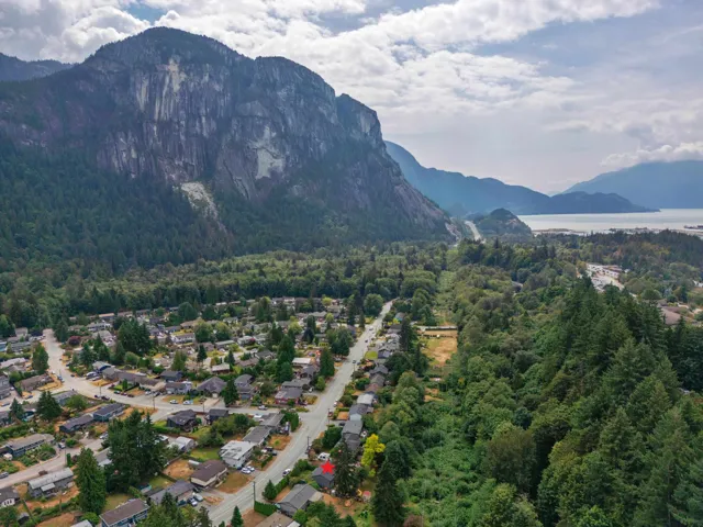 Aerial view of property and surrounding area featuring a water and mountain view and nearby suburban area