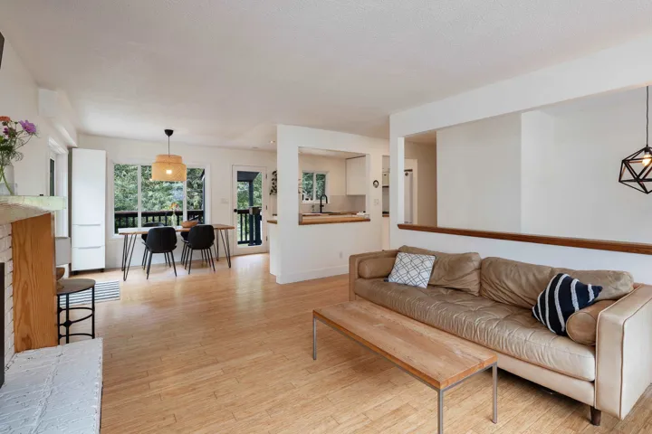 Living area featuring light wood finished floors, a textured ceiling, and a brick fireplace
