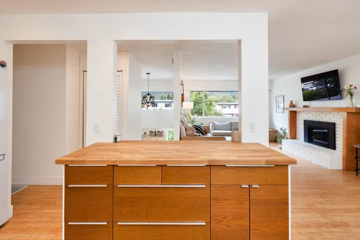 Kitchen with butcher block counters, light wood finished floors, a fireplace, and modern cabinets