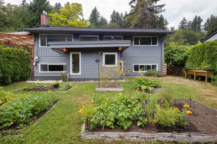 Rear view of property with a garden, a lawn, and a chimney