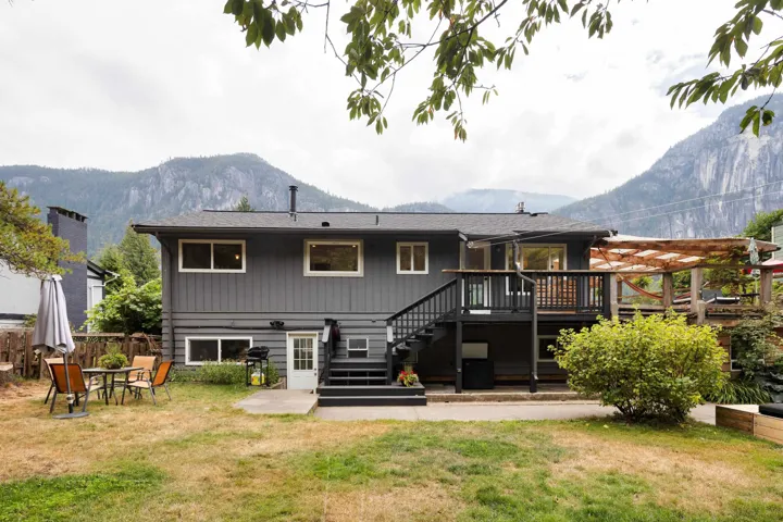 Back of property with stairway and a deck with mountain view