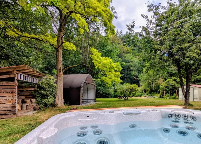 View of patio / terrace with a hot tub and a storage unit