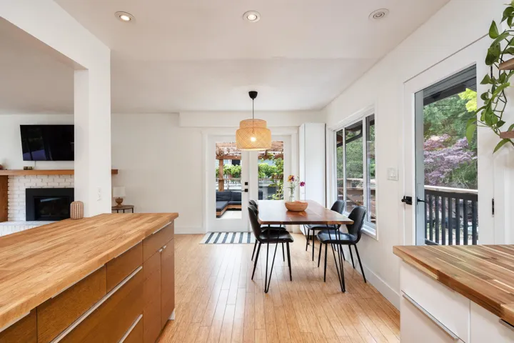 Dining room with french doors, light wood-style floors, recessed lighting, and a fireplace
