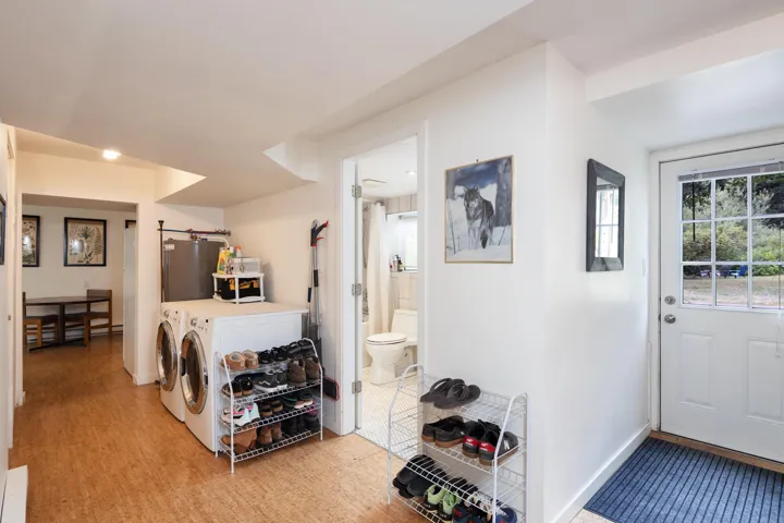 Washroom with independent washer and dryer, water heater, a barn door, and light wood-style floors