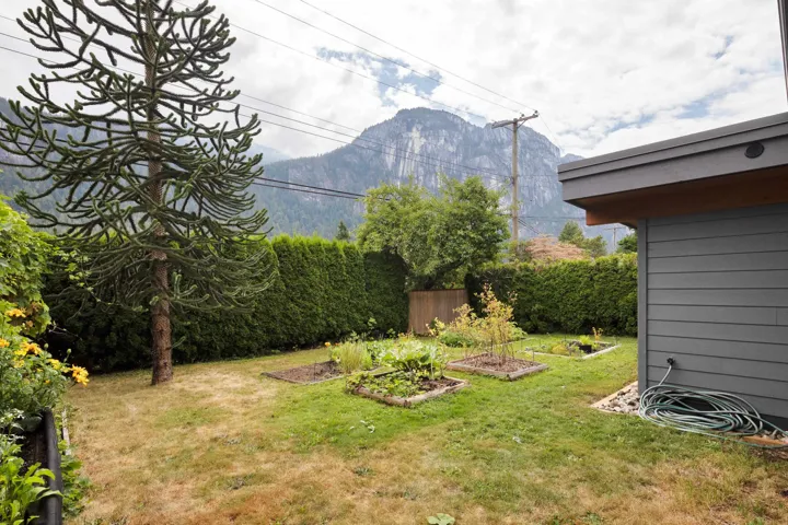 View of green lawn featuring a garden and a mountain view