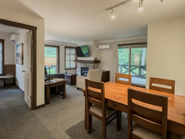 Dining room with a fireplace, carpet flooring, track lighting, and a wall mounted AC
