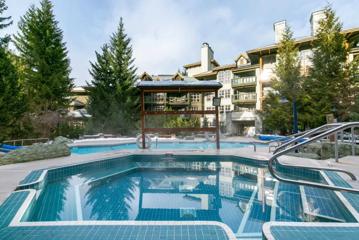Community pool with a patio and a hot tub