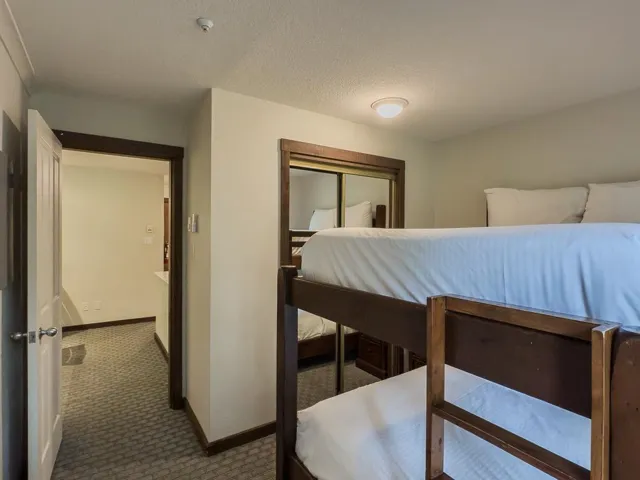 Carpeted bedroom with a textured ceiling and a closet