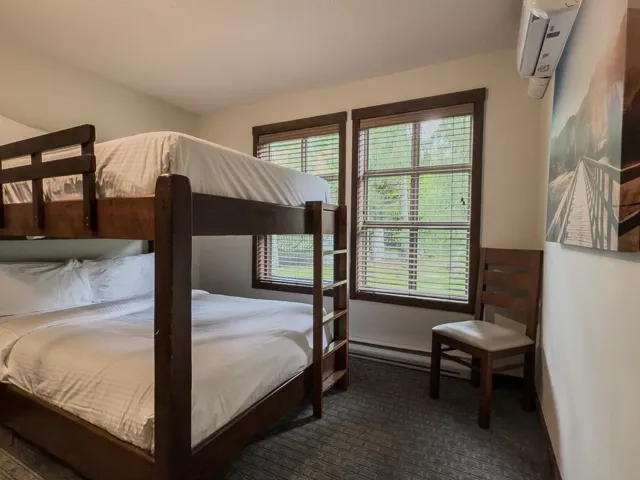 Bedroom with dark carpet and a wall mounted air conditioner