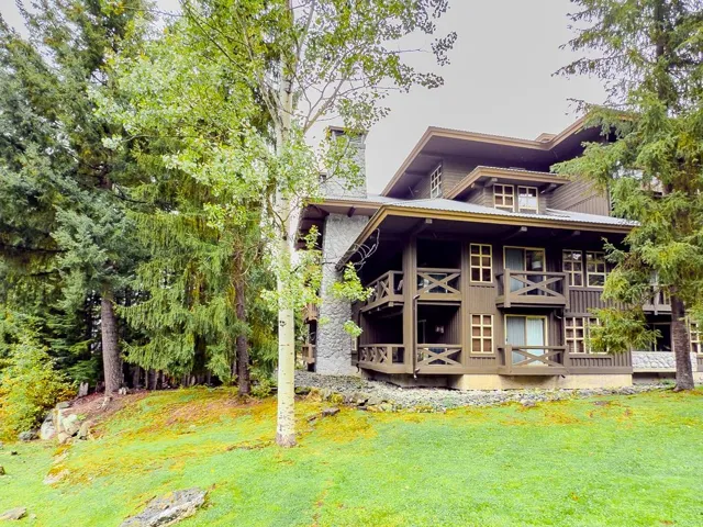 Rear view of property featuring a lawn and board and batten siding