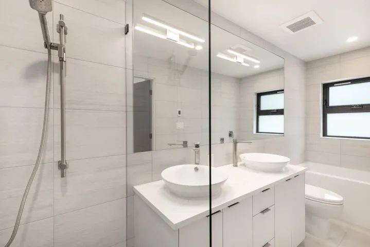 Bathroom featuring tile walls, double vanity, a shower, and a tub to relax in