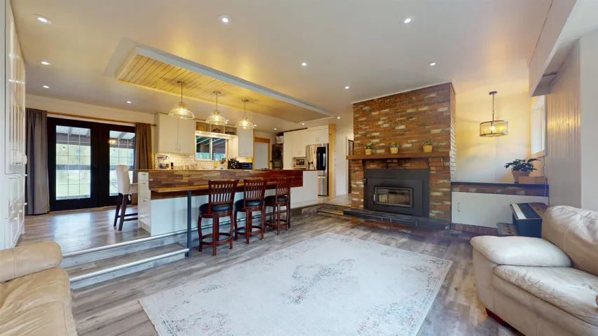 Living area featuring recessed lighting, french doors, wood finished floors, and a fireplace