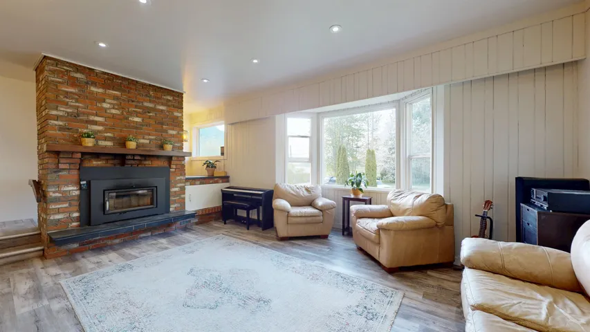 Living room with recessed lighting, wood finished floors, and a brick fireplace