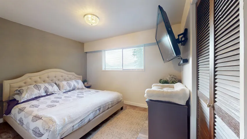 Bedroom with wood finished floors and baseboards
