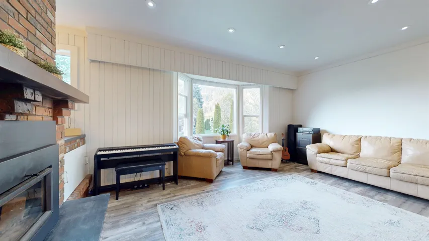 Living room featuring a glass covered fireplace, wood finished floors, recessed lighting, and ornamental molding