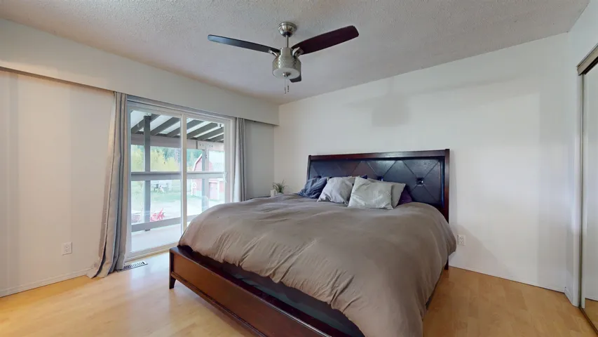 Bedroom featuring a textured ceiling, light wood-type flooring, a ceiling fan, and access to outside